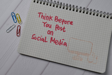 Think Before You Post On Social Media write on a book isolated on wooden table.