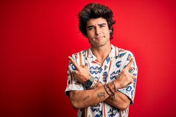 Young handsome man on vacation wearing summer shirt over isolated red background Pointing to both sides with fingers, different direction disagree