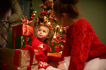 Little sisters unpack gifts smile laugh Cozy atmosphere of Christmas New Year Christmas tree...