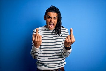 Young handsome african american afro man with dreadlocks wearing casual striped sweater Showing...
