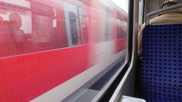 The view Through dirty Window of a moving commuter train in Hamburg  on the fields sweeping outside the window