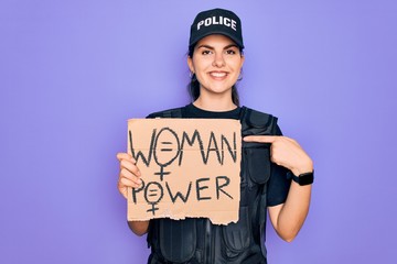 Police woman wearing security bulletproof vest uniform holding woman power protest cardboard with surprise face pointing finger to himself