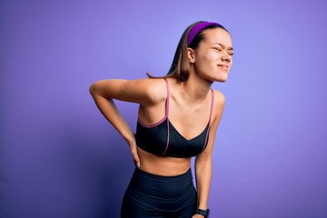 Young beautiful sporty girl doing sport wearing sportswear over isolated purple background...