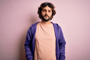 Young handsome sporty man with beard wearing casual sweatshirt over pink background looking sleepy and tired, exhausted for fatigue and hangover, lazy eyes in the morning.