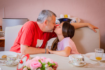 Obraz na płótnie Canvas Father in love and daughter is kissing while is having breakfast - .Father and daughter having breakfast and looking at each other