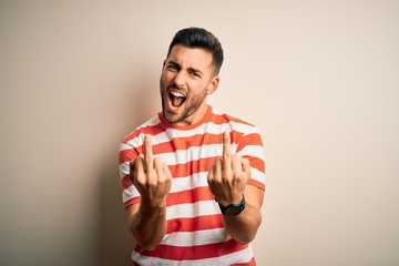Young handsome man wearing casual striped t-shirt standing over isolated white background Showing...