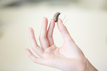 Very small hearing aid in a female hand