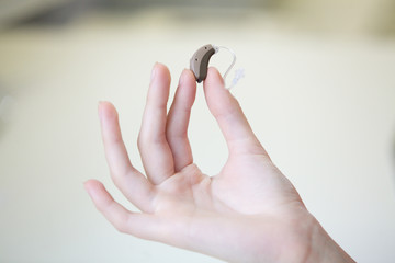 Very small hearing aid in a female hand