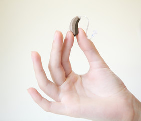 Very small hearing aid in female hands