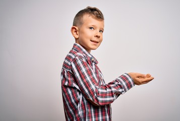 Young little caucasian kid with blue eyes wearing elegant shirt standing over isolated background pointing aside with hands open palms showing copy space, presenting advertisement smiling excited