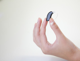 Very small hearing aid in a female hand