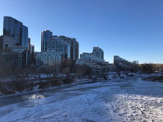 Calgary downtown city view in the winter. Frozen Bow River in Calgary downtown. Alberta, Canada. Oil and gas capital of Canada. 