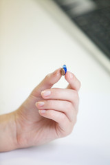 Very small hearing aid in a female hand
