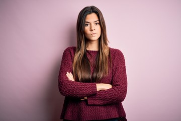 Young beautiful girl wearing casual sweater over isolated pink background skeptic and nervous,...