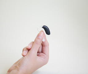 Very small hearing aid in a female hand