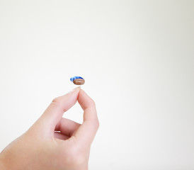 Very small hearing aid in a female hand