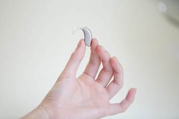 Very small hearing aid in female hands