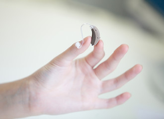 Very small hearing aid in female hands