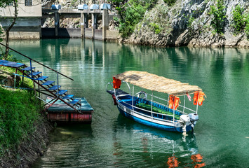 Obraz premium Small tourists transportation Blue boat docked in the small bay at Matka Canyon, Skopje, Macedonia