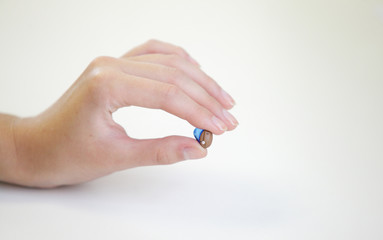 Very small hearing aid in a female hand