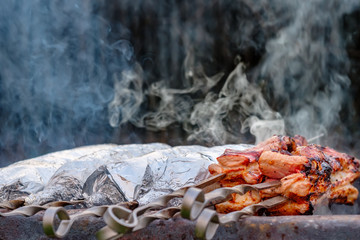  Juicy and fresh slices of pork are strung on metal skewers, wrapped in aluminum foil and grilled...