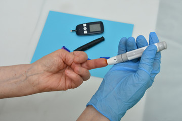 Doctor checking blood sugar level with glucometer. 