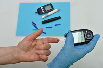 Doctor checking blood sugar level with glucometer. 