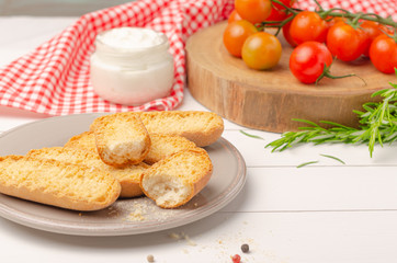 Vegetarian toasts with cream cheese tomatoes arugula rosemary and black pepper on rustic wooden table