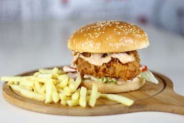 Fried Chicken Burger Sandwich with Fries on a Wooden Dish