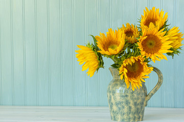 Sunflowers. Summer bouquet in crockery with pastel background.