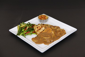 Grilled Chicken Fillet Steak with Mushroom sauce served on a white plate