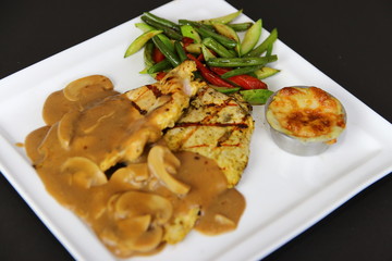 Grilled Chicken Fillet Steak with Mushroom sauce served on a white plate