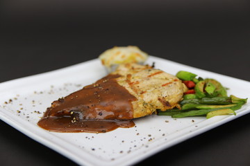 Chicken Fillet Steak Grilled with Black Pepper Sauce served on a dish with mash potato and fresh beans