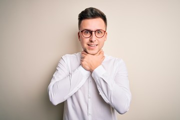 Young handsome business mas wearing glasses and elegant shirt over isolated background shouting and suffocate because painful strangle. Health problem. Asphyxiate and suicide concept.