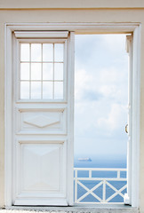 white door opening to blue sea