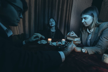 People hold hands of night at table with candles