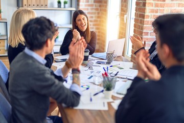 Group of business workers smiling happy and confident. Working together with smile on face applauding one of them at the office