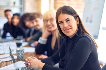 Group of business workers sitting in line with smile on face. Looking at the camera, young beautiful woman smiling at the office