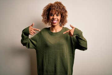 Beautiful african american woman with curly hair wearing casual sweater over white background...