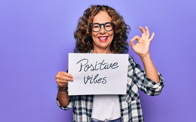 Middle age woman asking for optimistic attitude holding paper with positive vibes message doing ok...