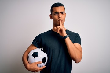 Handsome african american man playing footbal holding soccer ball over white background asking to...