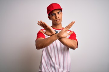 Young handsome african american sportsman wearing striped baseball t-shirt and cap Rejection...