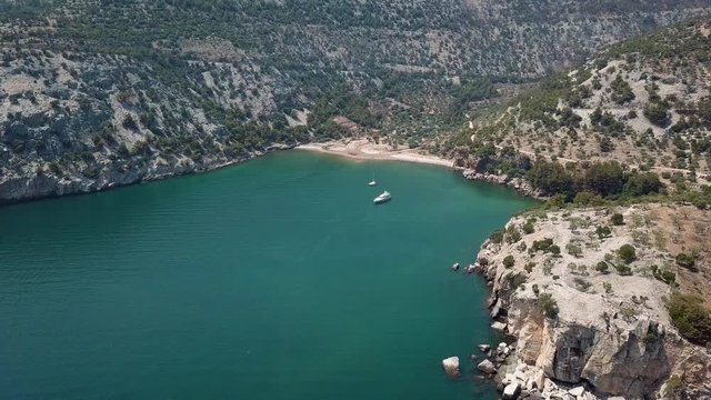 scenic aerial view of a yacht between reefs in a bay on a greek island thasos