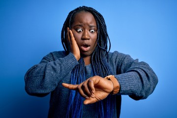 African american plus size woman with braids wearing casual sweater over blue background Looking at...