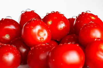 Appetizing tomatoes with drops of water isolated on a white background. Copy space.