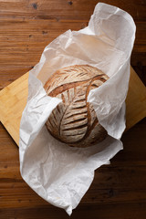 Fototapeta na wymiar sourdough bread on delivery paper on wooden table