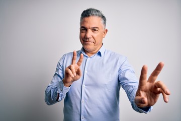 Middle age handsome grey-haired business man wearing elegant shirt over white background smiling looking to the camera showing fingers doing victory sign. Number two.