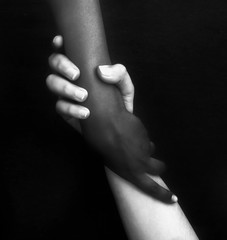 Monochromatic photo for two hands different in colors / black and white, showing unity, harmony,...