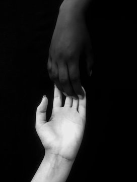 Monochromatic photo for two hands different in colors / black and white, showing unity, harmony, integration, and acceptance fighting against racism,prejudice, discrimination, racialism and xenophobia