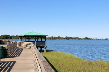 Wooden boardwalk during sunny summer with lake view